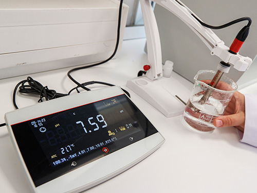 scientist testing a water sample with a pH meter.